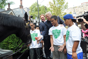 Donald Trump and Mark Bellissimo, CEO of Equestrian Sport Productions, joined by youth from the Police Athletic League NYC, feed an apple to NYPD Mounted Unit horse Torch, after announcing that the first ever 