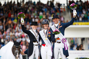 Pictured at the prize-giving for the Grand Prix Special at the FEI European Dressage Championships in Aachen, Germany: (L to R) silver medallist Kristina Bröring-Sprehe (GER), gold medallist Charlotte Dujardin (GBR) and bronze medallist Hans Peter Minderhoud (NED). Photo by FEI/Dirk Caremans