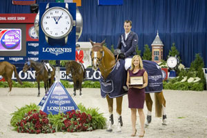Harrie Smolders (NED) and Emerald (left), winners of the Longines FEI World Cup™ Jumping at the Washington International Horse Show, were presented with a Longines watch by Taylor Mace, National Event Manager for Longines. Photo by StockImageServices.com/FEI