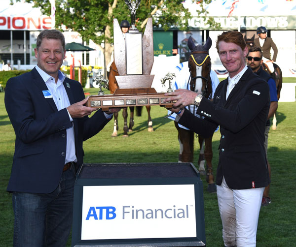 Daniel Coyle (IRL) winner of the ATB Financial Cup raises the trophy with Curtis Stange, Chief Customer Officer, ATB Financial. Photo © Spruce Meadows Media