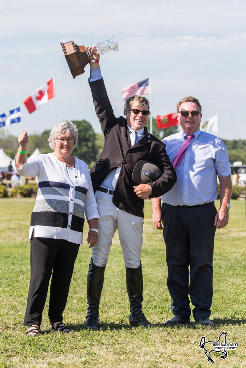 Hugh Graham, center, hoists the trophy following his win in the $132,000 CSI3* Ottawa International Grand Prix. Presenting on behalf of Wesley Clover Parks are Lady Ann Matthews ﻿and Chief Operating Officer, Tony Dunn.