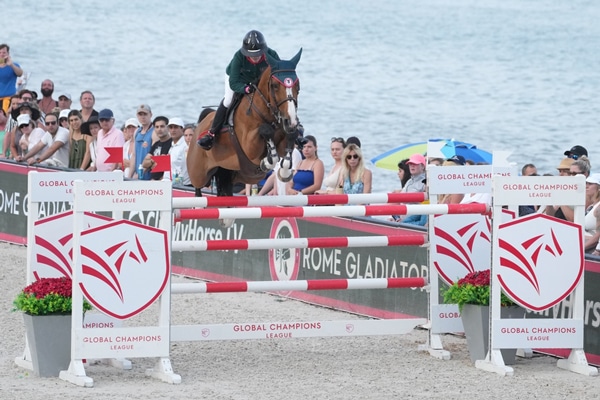 Beth Underhill and Nikka Vd Bisschop jumping a fence on Miami Beach.
