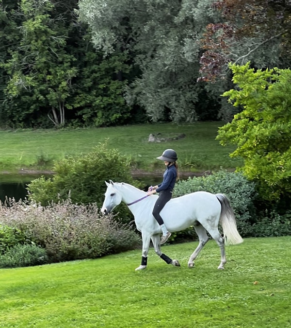 Mathilde hacking her grey pony Ulior bareback and bridleless around the family's farm. 