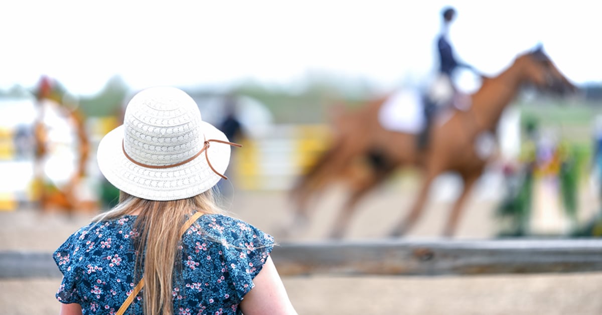 A person watching a horse compete.