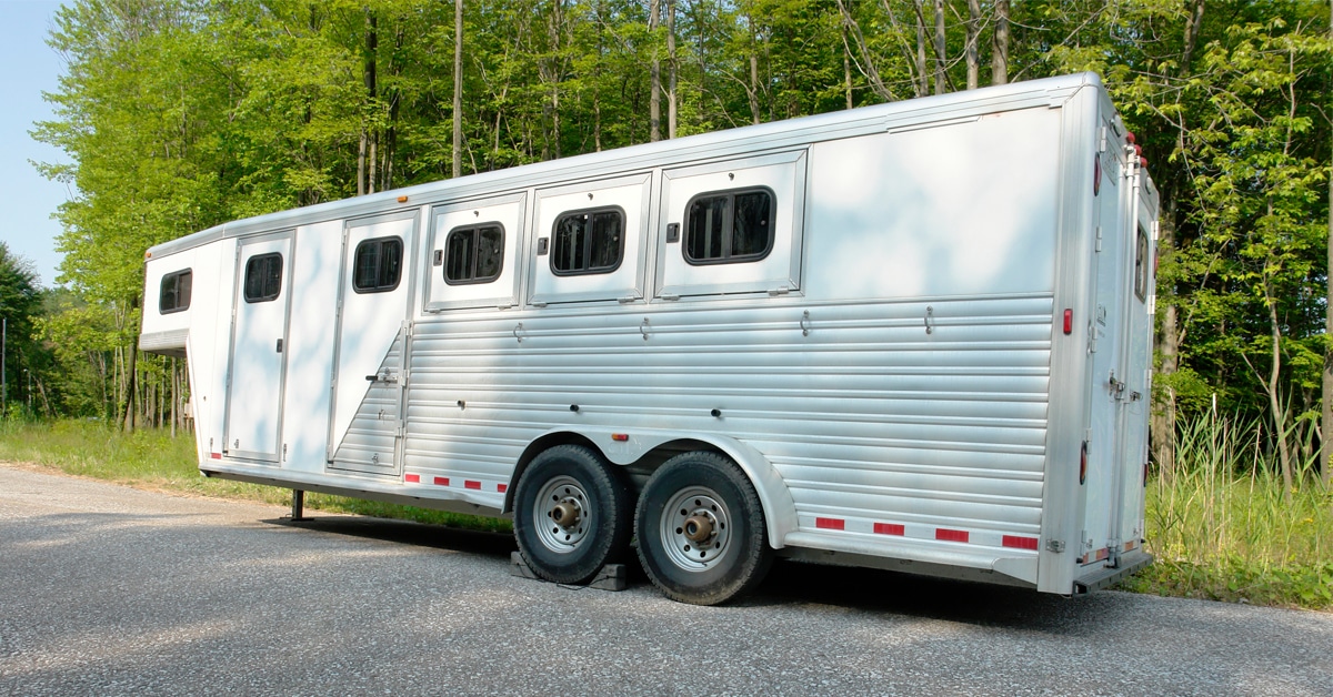 A large horse trailer parked on the road.