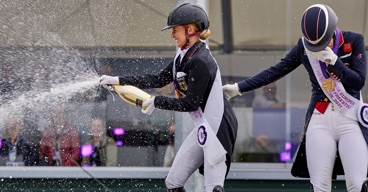 Dressage rider opening champagne on the podium.