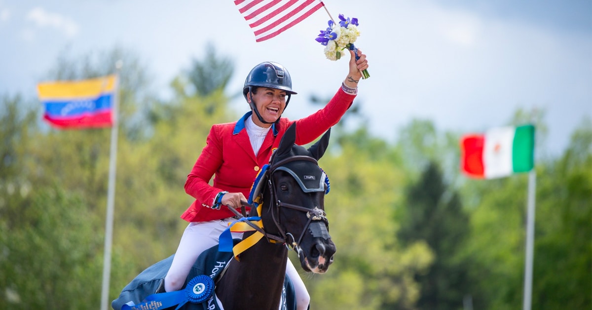 Tamie Smith riding Mai Baum, waving a US flag in the victory gallop.