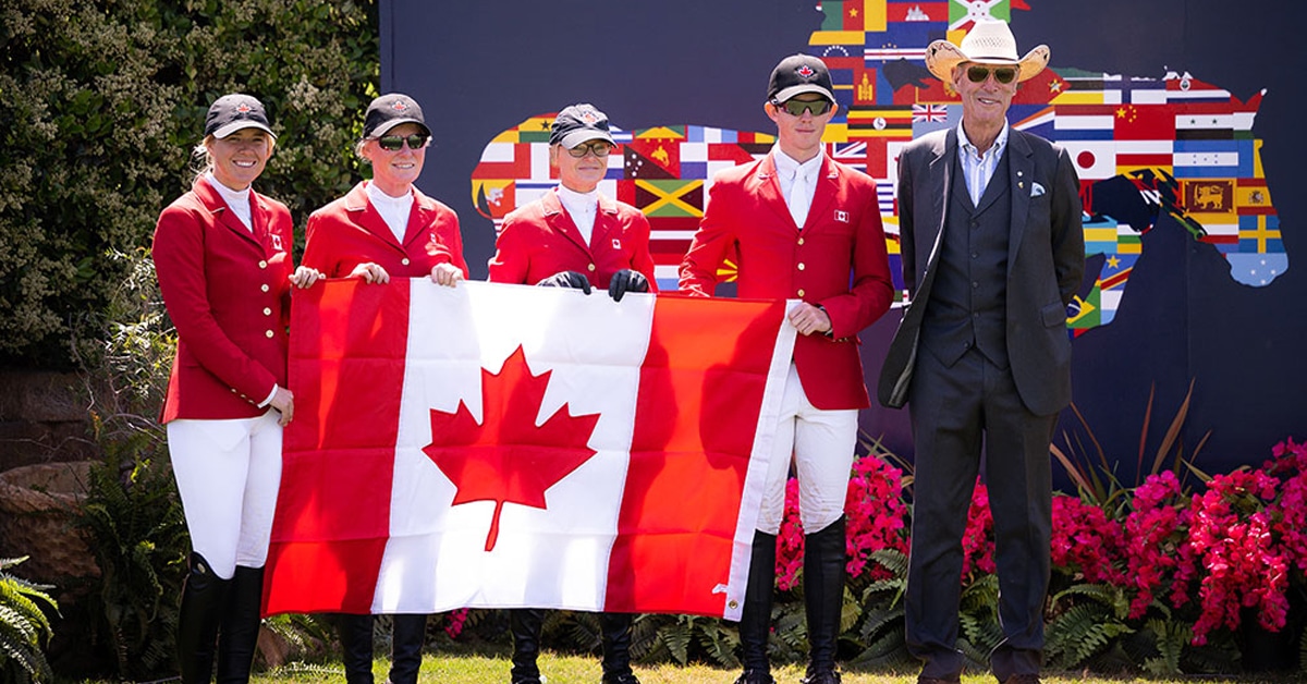 Canadian Show Jumping team standing with a Canadian flag.