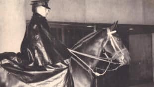 A black-and-white photo of a mounted policeman on a horse.