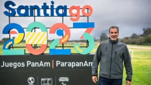 Cesar Hirsch standing in front of a Pan Am Games sign.