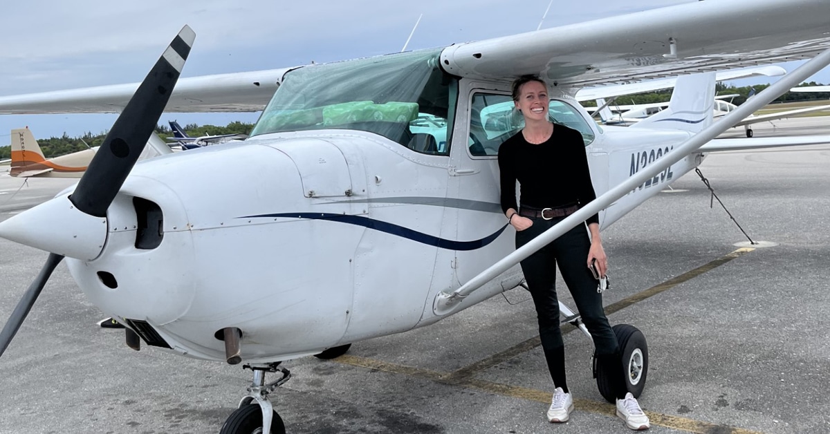 Megan Lane standing beside a small plane.