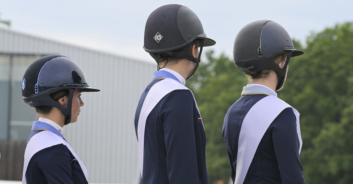 Three teens wearing helmets.