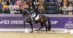 A horse and rider performing dressage in an arena.