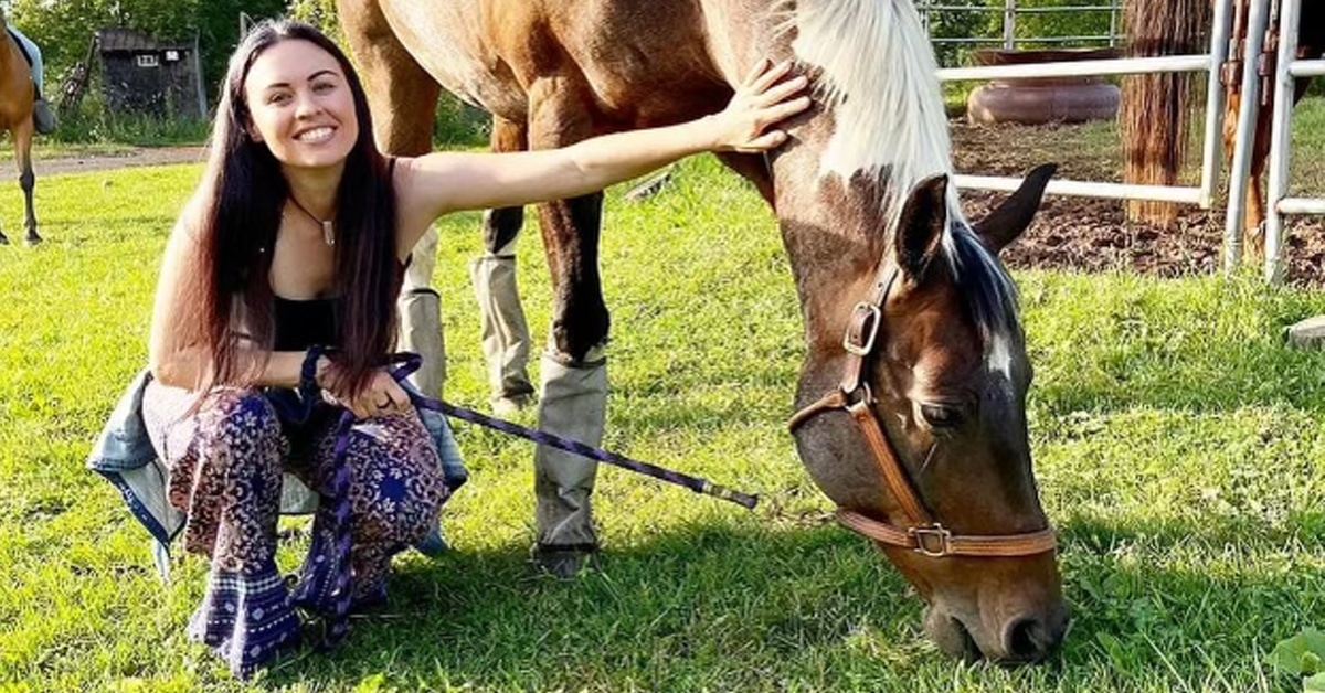 A woman patting a horse.