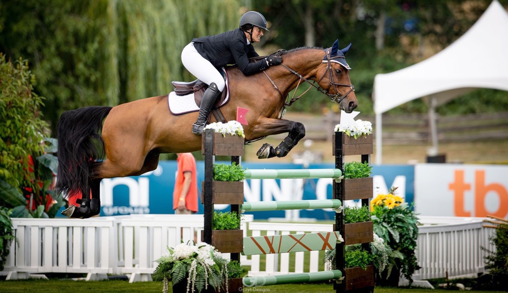 A horse and rider jumping afence.