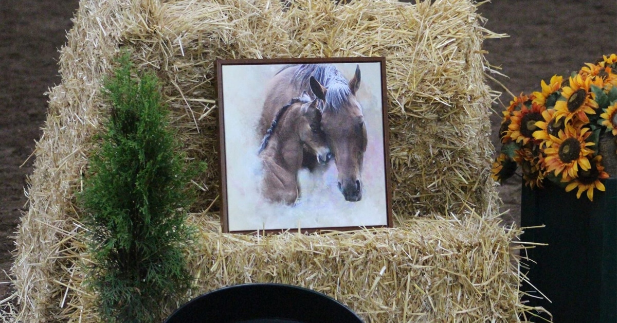 A painting of a mare and foal sitting on a hay bale.
