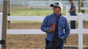 A woman holding a coffee in a warmup ring.