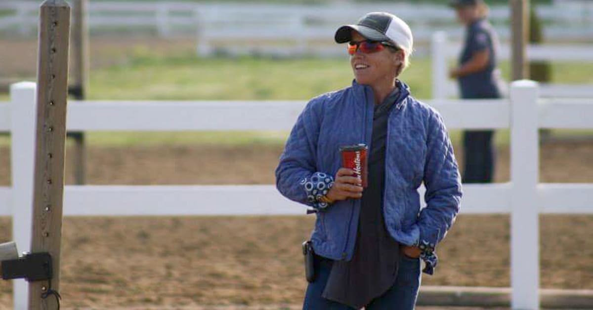A woman holding a coffee in a warmup ring.