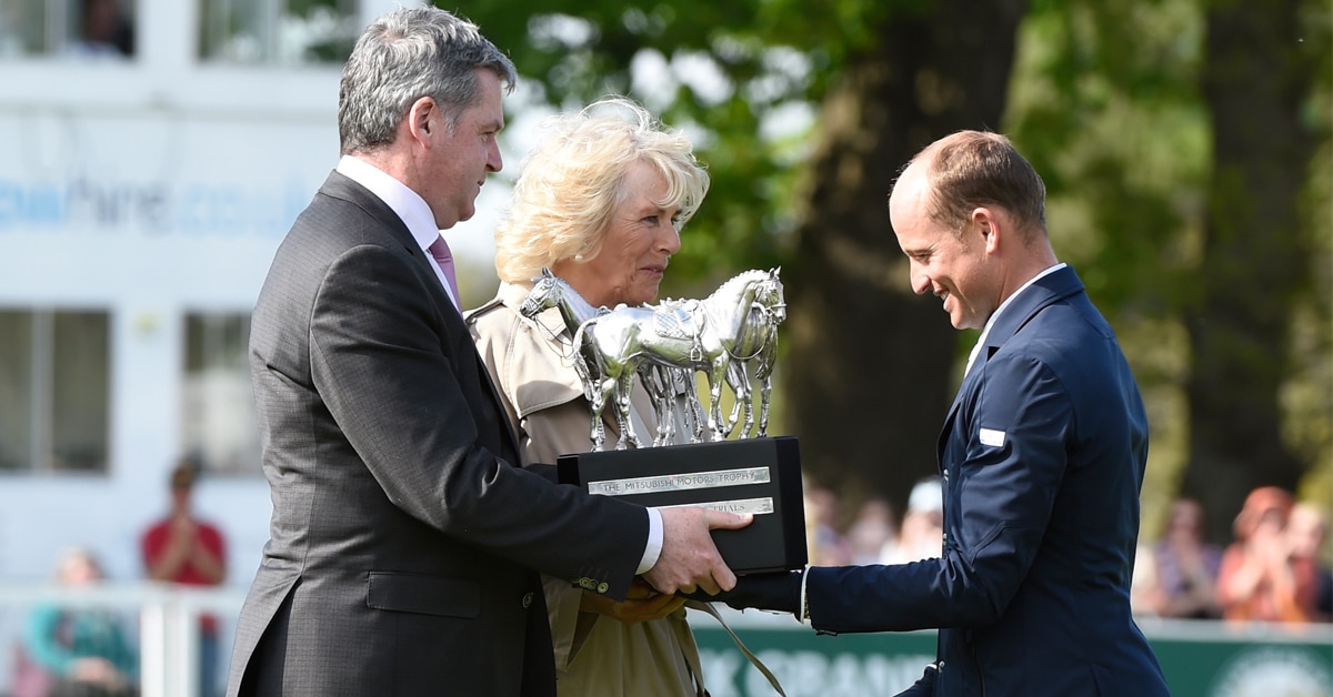 Camilla presenting a trophy to a rider.