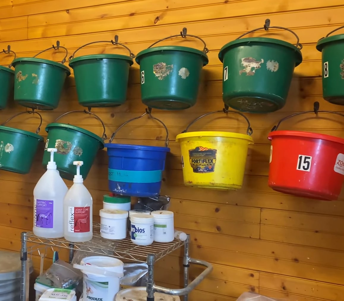 A row of buckets hanging on the wall.