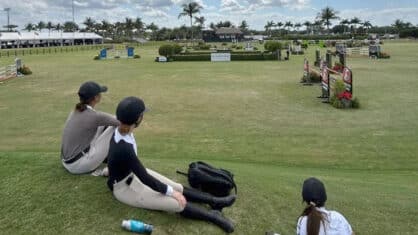 Thee young women watching a horse show in Florida.