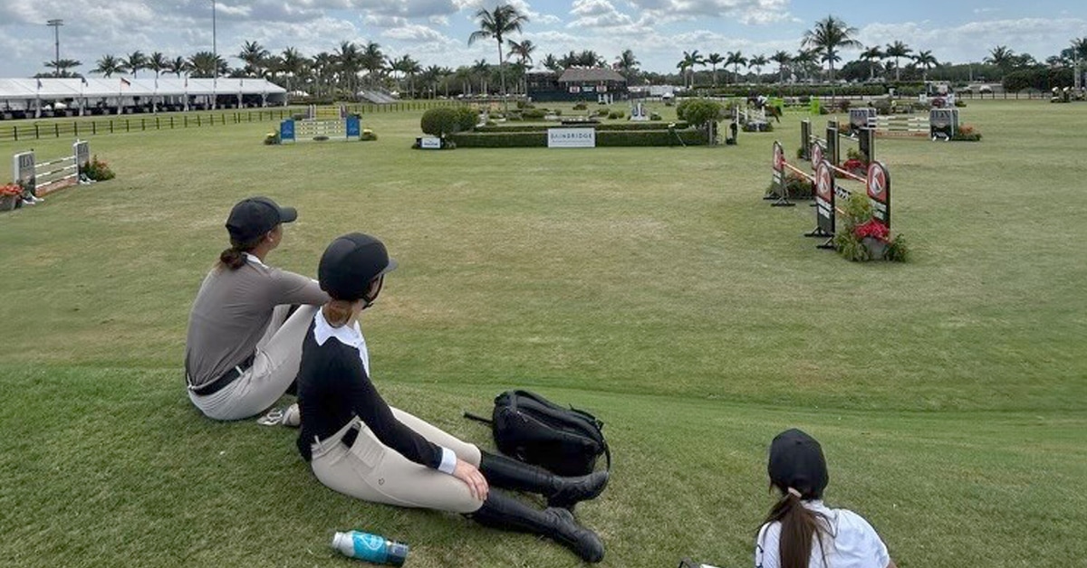 Thee young women watching a horse show in Florida.
