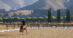 A person riding in a dressage ring with mountains in the background.