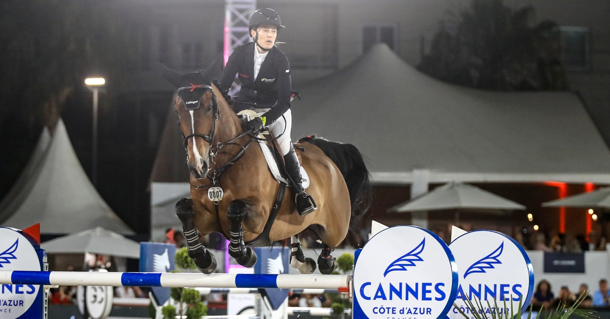 A horse and female rider jumping a fence in Cannes.