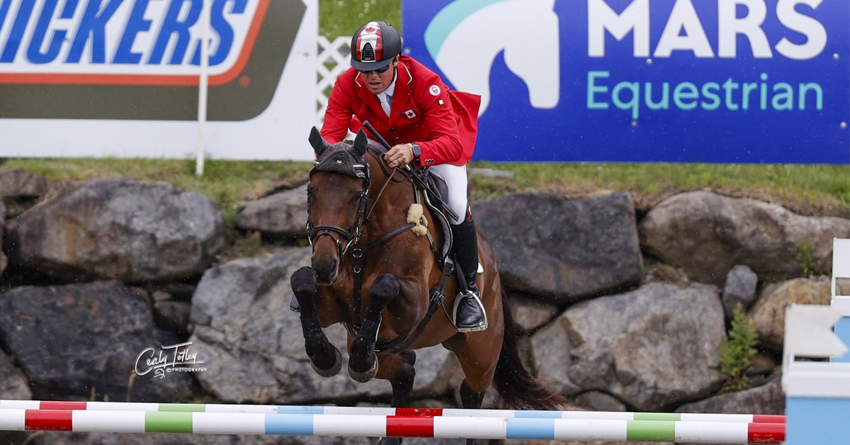A man jumping a bay horse over a fence at Bromont.