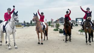 Four riders with hands raised in triumph.